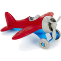 Red and blue toy airplane with a grey three-blade propeller and wheels. Chunky, rounded plastic design.
