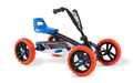 Four-wheel pedal go-kart with off-road orange tires, black frame, blue seat, and visible blue suspension springs.