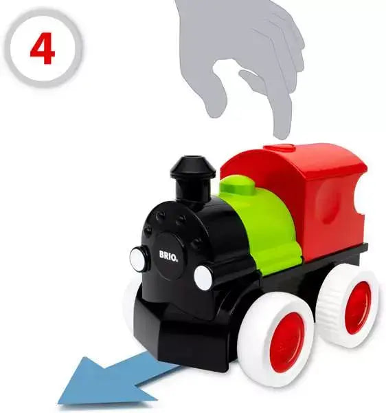 Hand pressing a button on a black, green, and red BRIO toy train engine with white wheels moving forward.