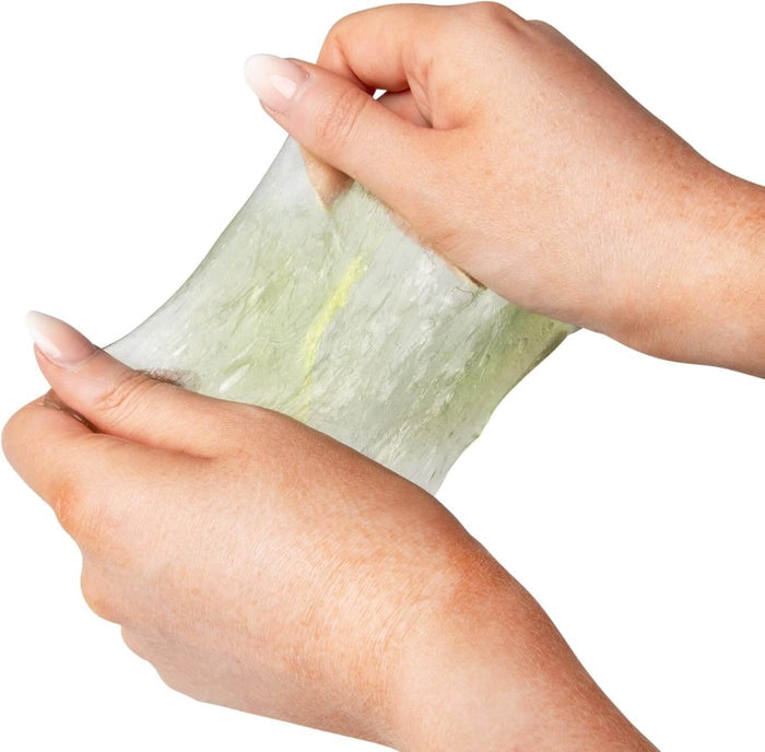 Two hands stretching a translucent, pale yellow sheet of putty containing small capybara-shaped charms.