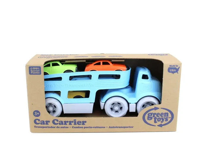 Blue toy car carrier truck with lime green and orange cars, displayed inside its cardboard box packaging.