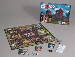Cluedo board game with blue castle-themed box, illustrated game board, cards, colorful tokens, and dice.