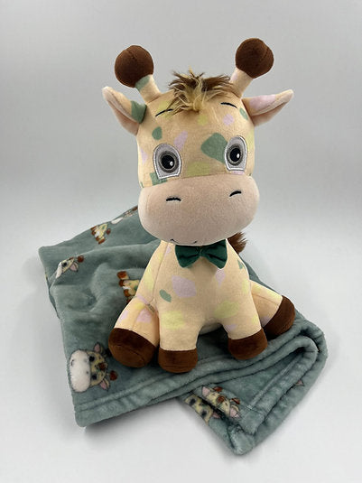 Pale yellow plush giraffe with pastel spots and a green bow tie on a folded sage green giraffe-print fleece blanket.