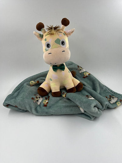 Yellow spotted giraffe plush with a dark green bow tie resting on a matching sage green patterned fleece blanket.