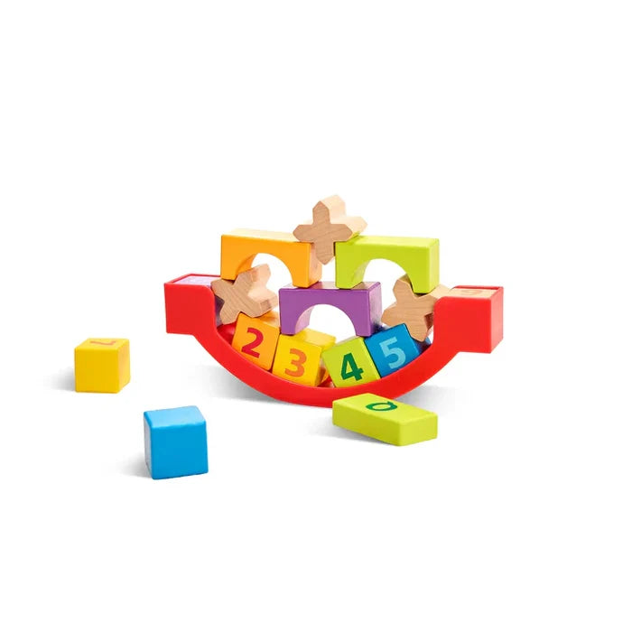 Colorful wooden arches, cubes, and numbered blocks balanced on a red curved rocking base.