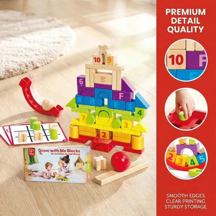 Tower of colorful wooden blocks with numbers and letters, a red marble run ramp, balls, and an activity guide book.