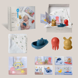 Baby bath kit with a white hooded towel, blue boat, red octopus, yellow bunny toys, and an illustrated soft book.