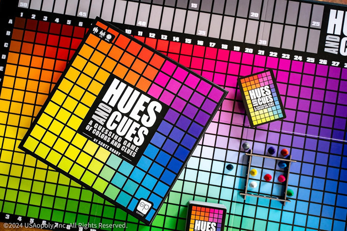 Hues and Cues board game box and board featuring a vibrant rainbow grid of colored squares and game pieces.