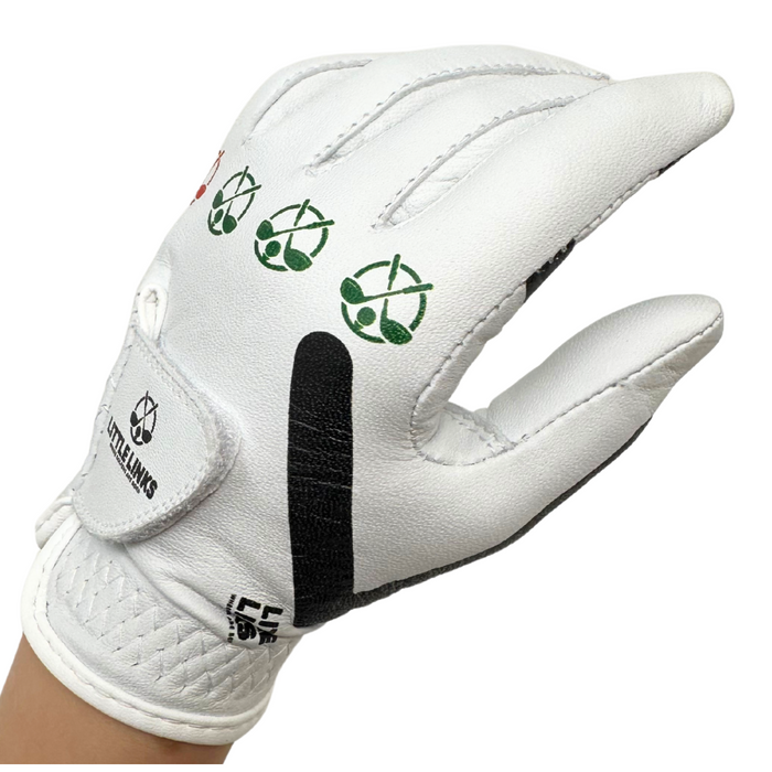 White leather kids golf glove with green club icons on the knuckles, black side stripe, and velcro logo strap.
