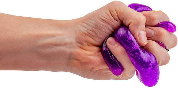 Hand squeezing vibrant purple, translucent slime with tiny bubbles against a plain white background.
