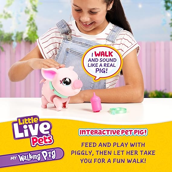 Young girl playing with a pink interactive toy pig, teal collar, bottle, and leash on a white table.