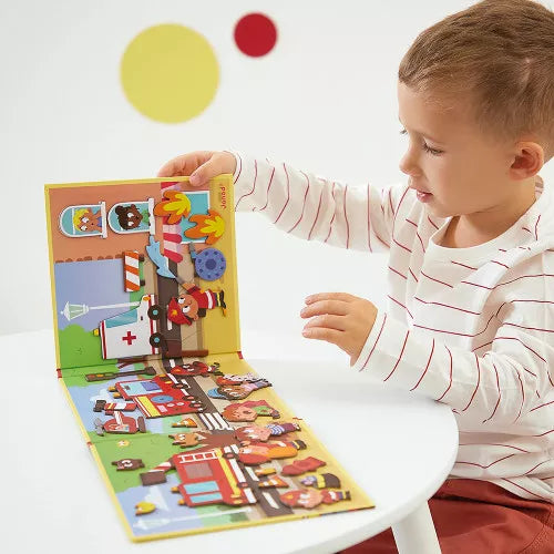 Child playing with a yellow trifold magnetic book featuring colorful fire trucks and rescue character magnets.
