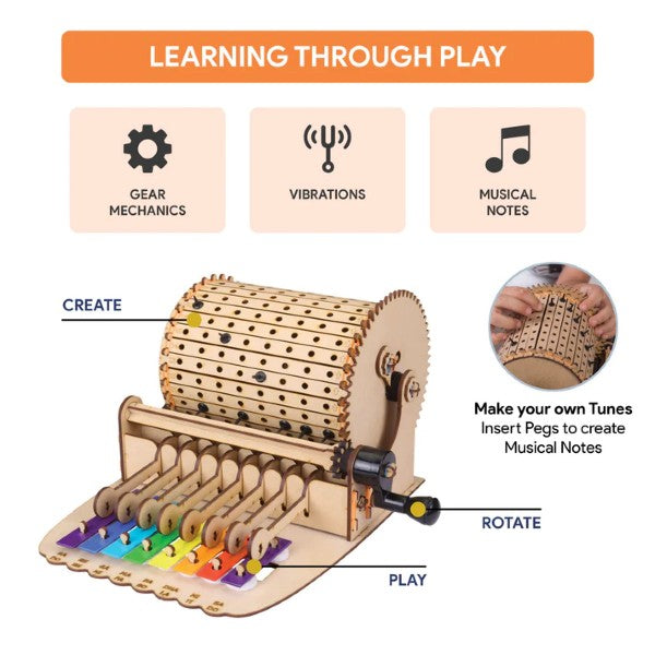 Wooden mechanical music box kit with rotating drum, customizable pegs, and rainbow-colored xylophone keys.