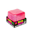 Bright pink, glittery translucent squishy cube in a black display tray with a sparkly interior.