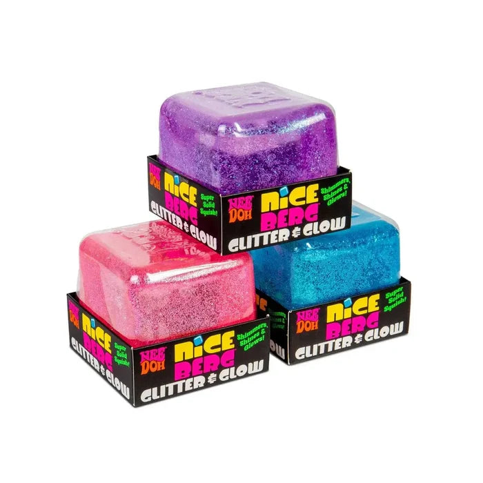 Three glittery pink, blue, and purple cube-shaped squish toys in black cardboard display boxes.