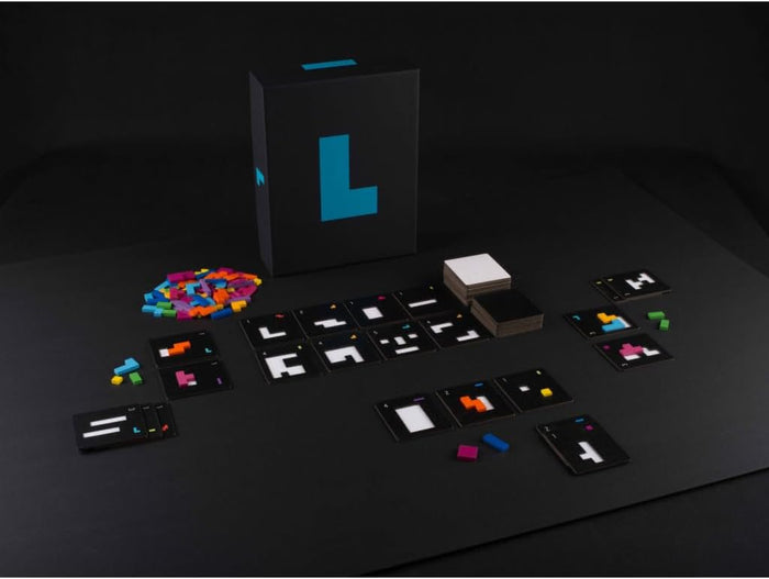 Black game box with a large cyan L, surrounded by vibrant plastic geometric pieces and black puzzle cards.