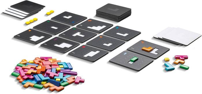 Black recessed puzzle tiles, square cards, and a pile of colorful plastic polyomino shapes on a white background.