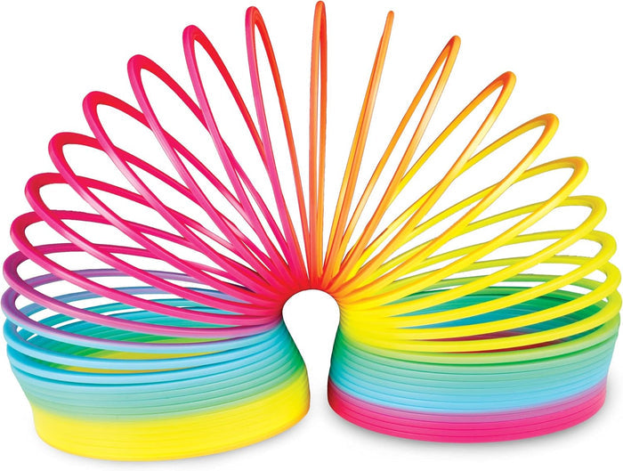 Vibrant plastic spring toy arched into a bridge, showing a rainbow gradient of neon yellow, pink, and blue coils.