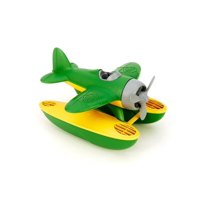 Green and yellow plastic toy seaplane featuring large pontoons and a gray three-blade propeller.