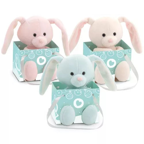 Three plush bunnies in pink, white, and blue with long ears sitting inside teal gift bags with white heart patterns.