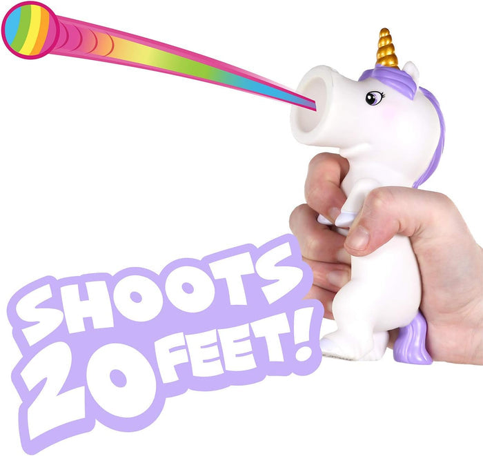 Hand squeezing white unicorn toy with gold horn, shooting a rainbow ball. Purple text: SHOOTS 20 FEET!
