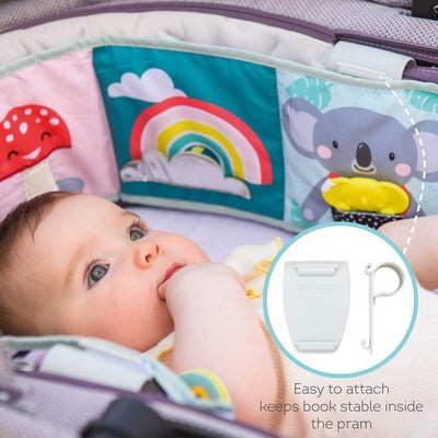 Baby looking at a colorful soft book with a koala, clipped to a pram. Inset shows white attachment clips.