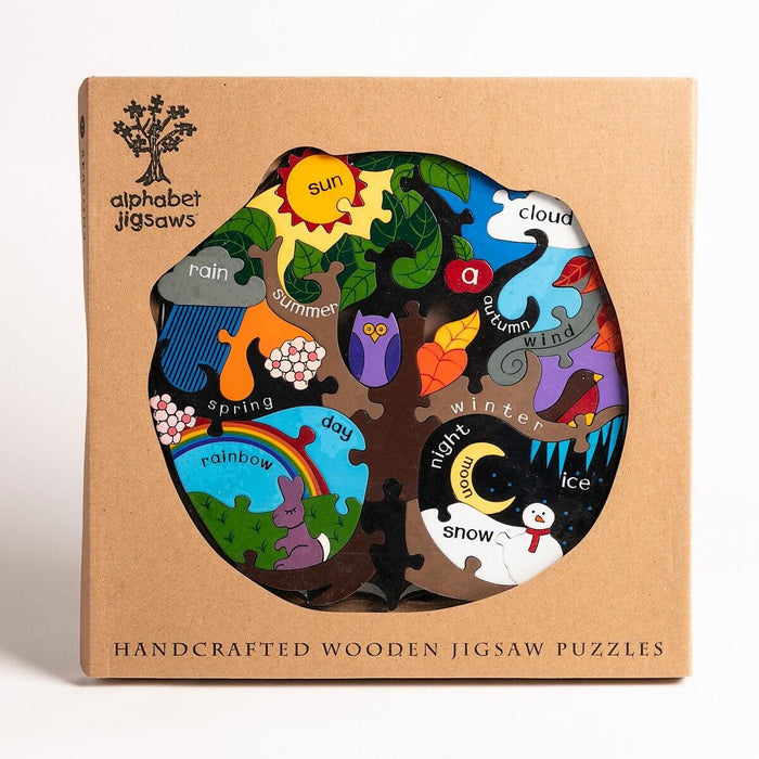 Wooden tree-shaped jigsaw in a cardboard box with colorful sections representing seasons, weather, and day/night.