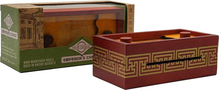 Dark red wooden puzzle box with gold fret patterns and sliding pegs, shown next to its green retail packaging.