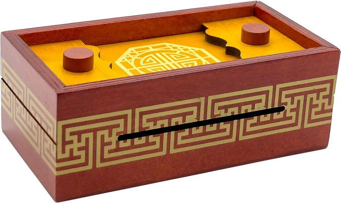 Red wooden puzzle box with gold fretwork patterns and a yellow sliding lid featuring two round wooden knobs.