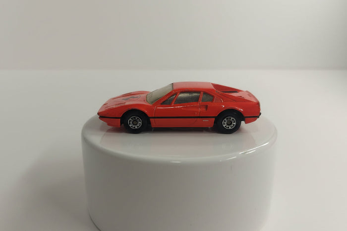 A red Matchbox Ferrari 308 GTB toy car on a plain background