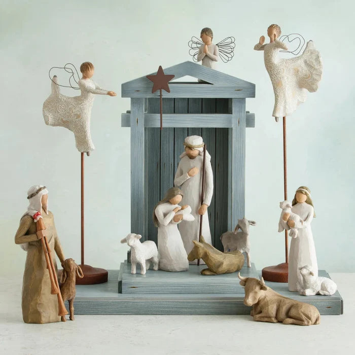 Nativity scene with figures including Mary, Joseph, baby Jesus, and animals on a light blue background.