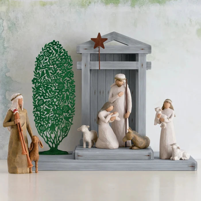 Nativity scene with figures and a tree on a white background