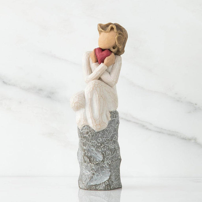 Statue of a woman holding a heart with a marble background