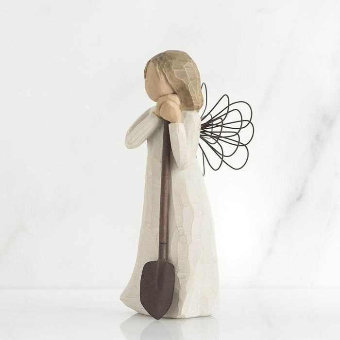 Angel figurine with a shovel on a white background