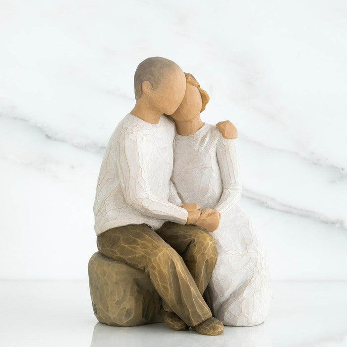 figurine of a couple embracing on a white background