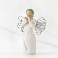 Angel figurine with outstretched wings holding a heart on a white background