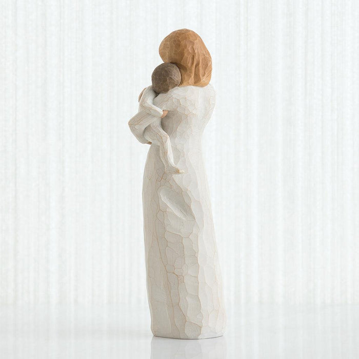 Statue of a woman holding a child on her back against a white background