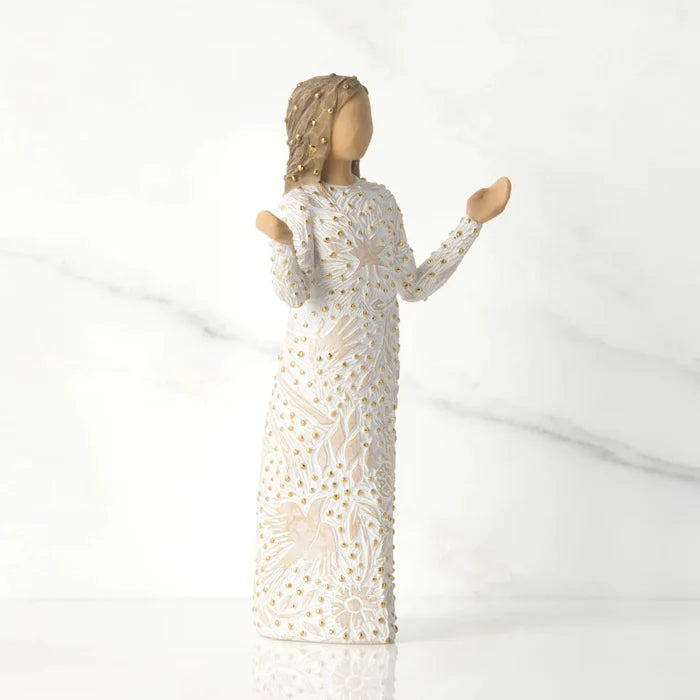 figurine  of a woman in a white dress with gold detailing on a white background