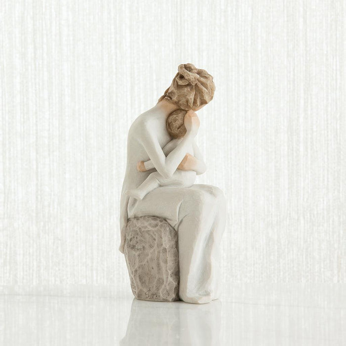 Statue of a woman sitting with a child in her lap on a white background