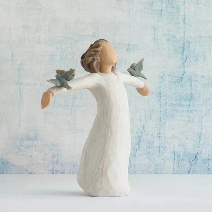 Angel figurine with outstretched arms against a textured blue and white background