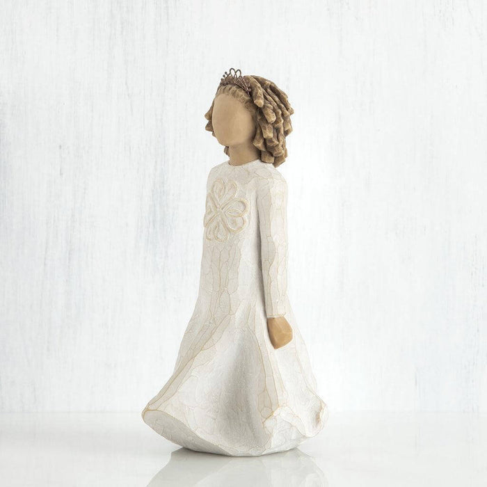 Statue of a woman in a long white dress with floral headpiece on a white background