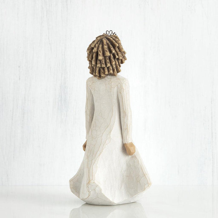 Statue of a woman with a flowing dress and braided hair on a white background