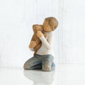 Figurine of a child hugging a teddy bear on a white background
