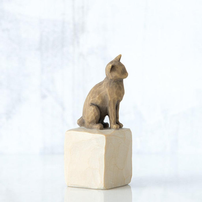 Statue of a sitting cat on a white cube with a white background
