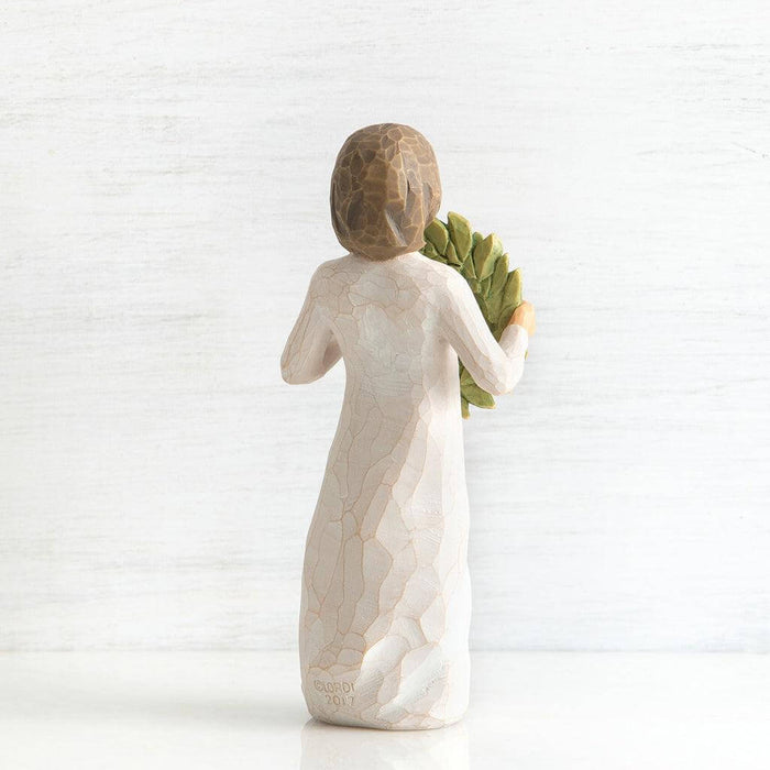 figurine of a woman holding leaves on a white background