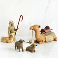 nativity scene figures including a shepherd, two sheep, and a camel on a white background