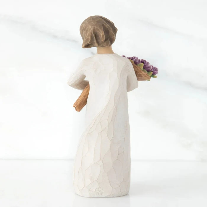 Backside of Hand-painted Willow Tree Surprise sculpture with purple bouquet on a white background