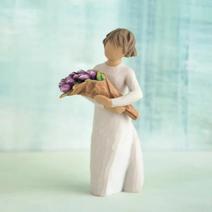 Hand-painted Willow Tree Surprise sculpture with purple bouquet on a blue background