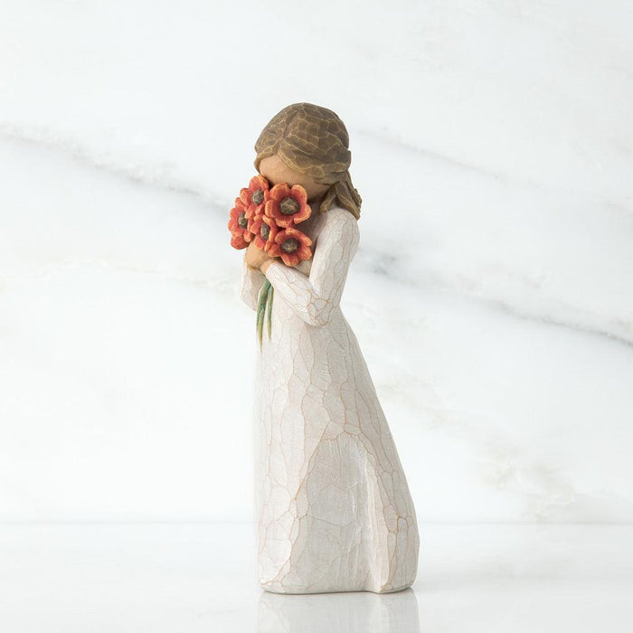 Decorative figurine of a woman holding flowers on a white background