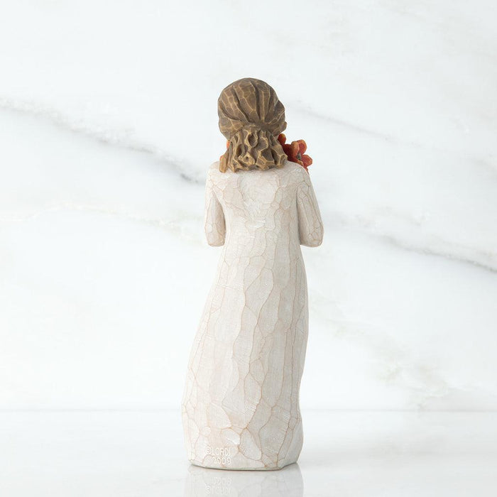 Statue of a woman with flowers her back against a white background
